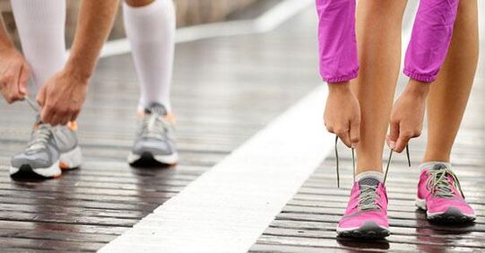 susiejant batų raištelius prieš bėgiojimą, norint numesti svorio