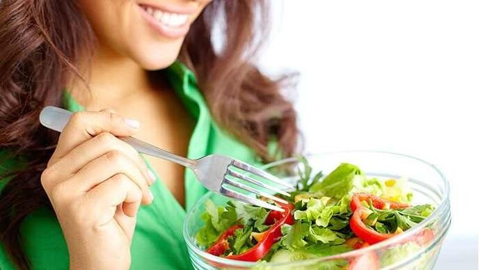 Mergina valgo daržovių salotas ir laikosi baltymų dietos